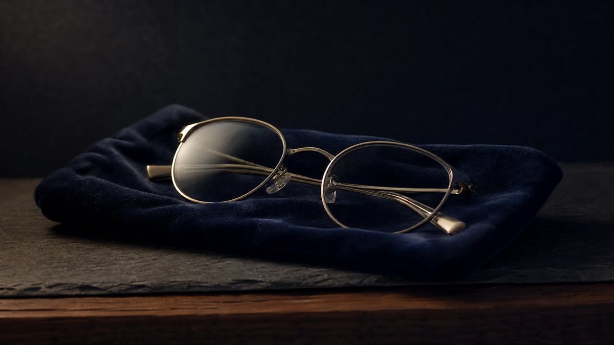 Thin metal-framed eyeglasses folded on navy velvet