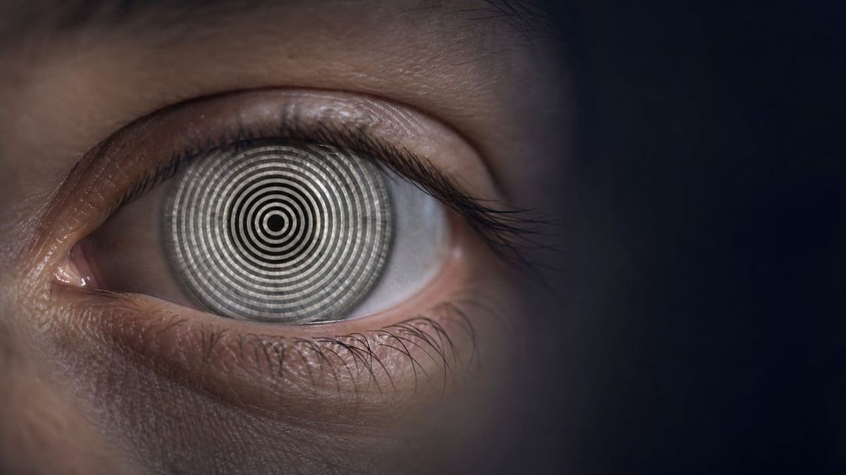 Close-up of an eye with concentric rings of light reflected across the cornea during topography