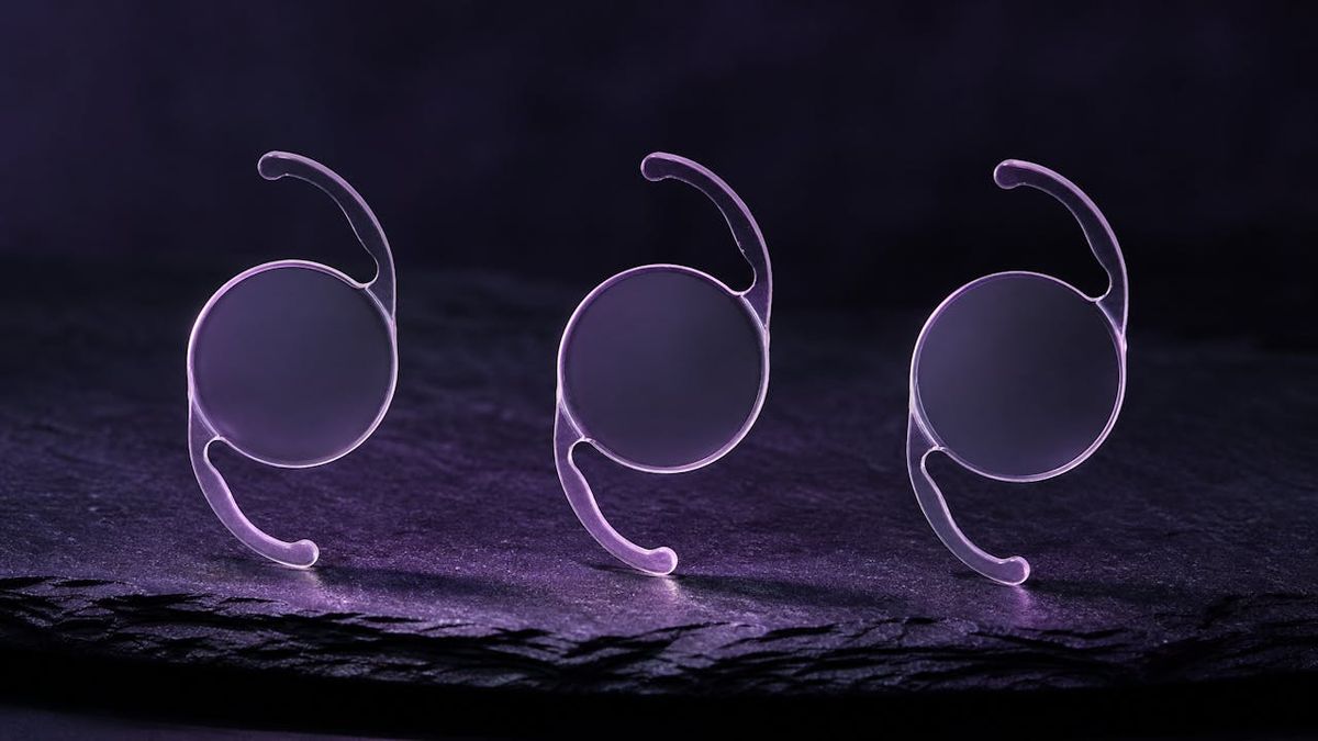 Three intraocular lens implants in a row under violet light, one for each adjustment